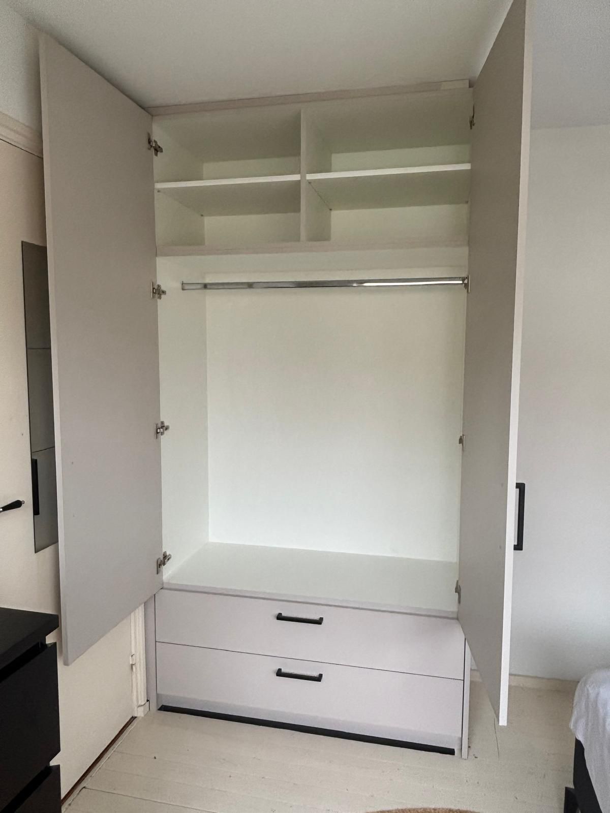 Witte kledingkast open met hangruimte