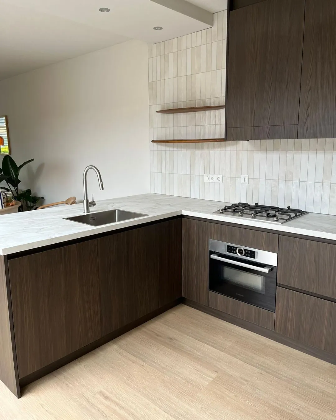 Maatwerk keuken met donker houtfineer en stenen werkblad